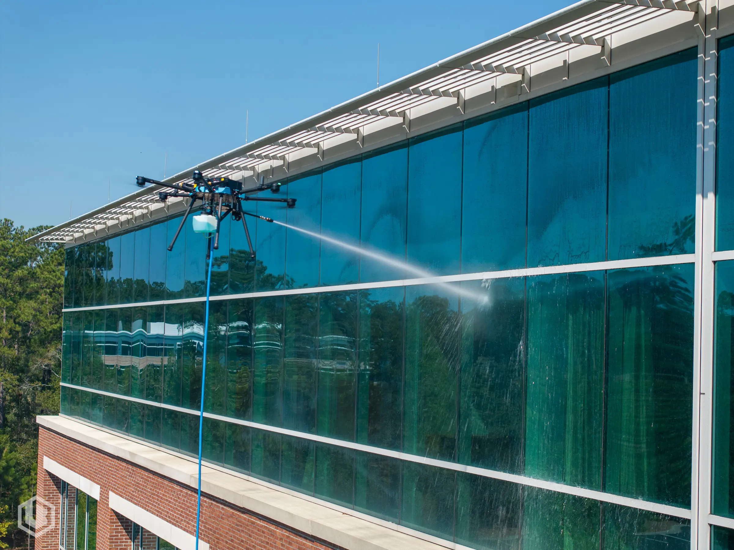 Drone restoring the exterior façade of a commercial office building, enhancing curb appeal and prolonging surface life.