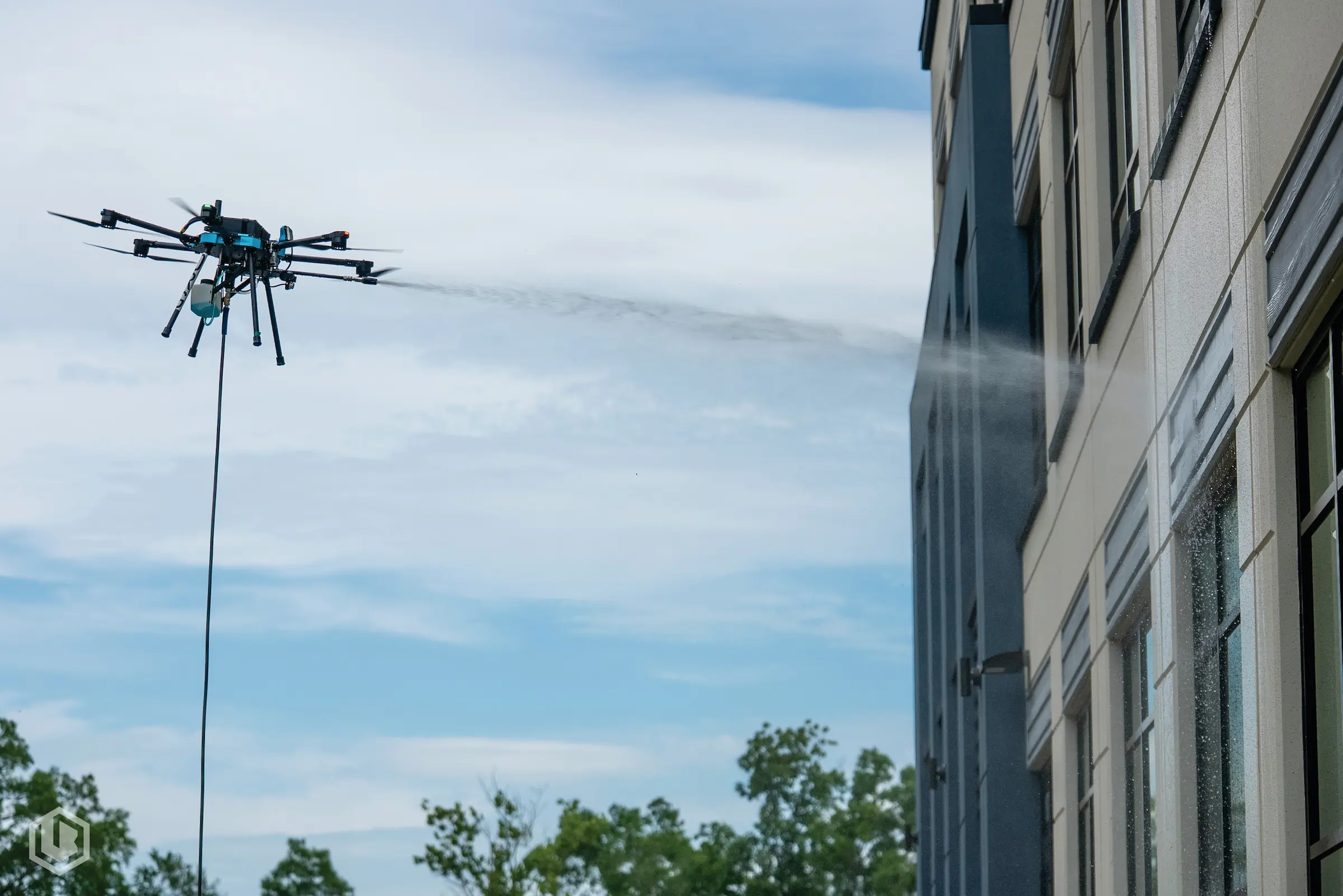 Drone restoring industrial facility windows for improved clarity and operational efficiency, without the need for scaffolding.