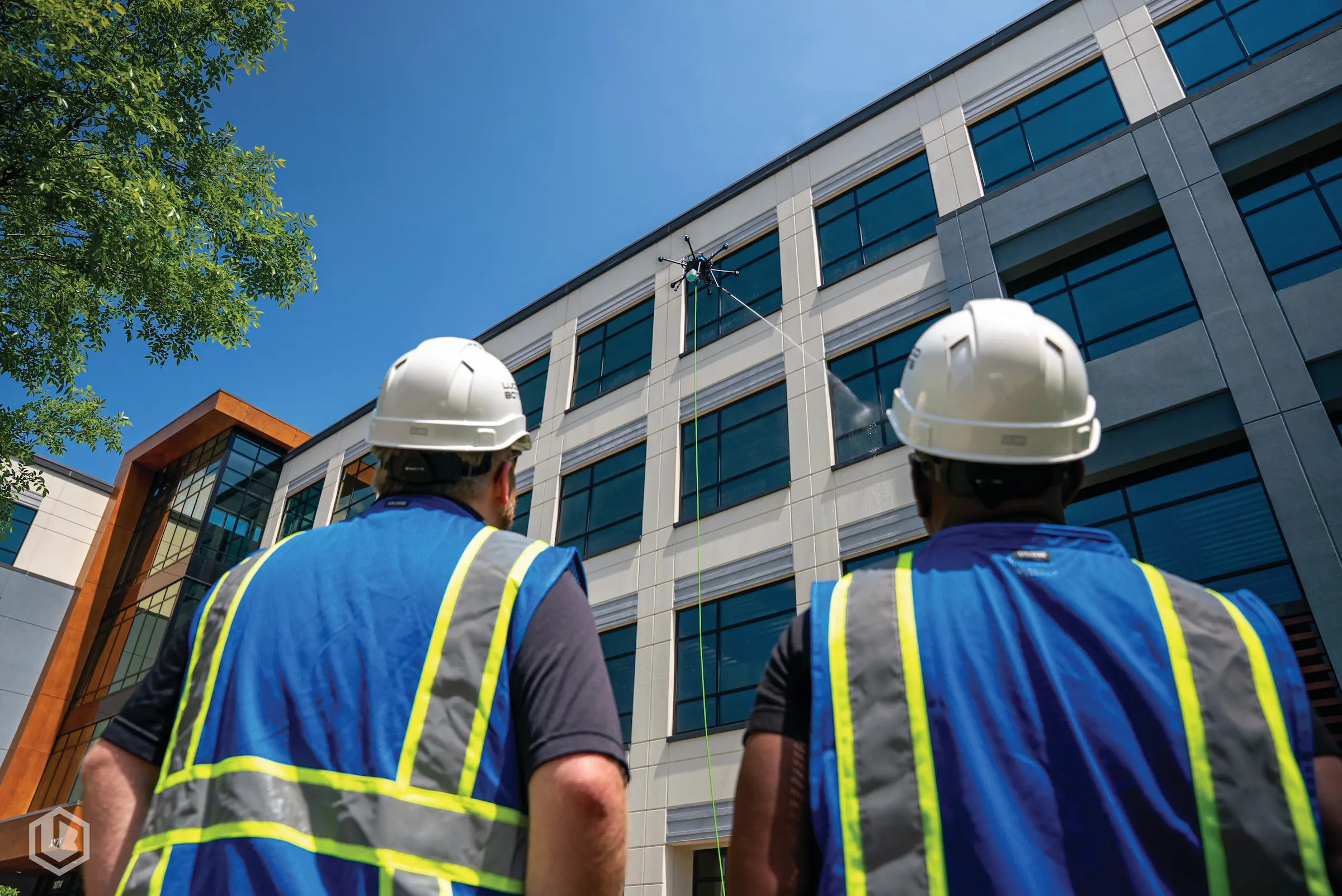 Drone power washing a retail center’s exterior, removing grime efficiently and minimizing disruption to tenants.